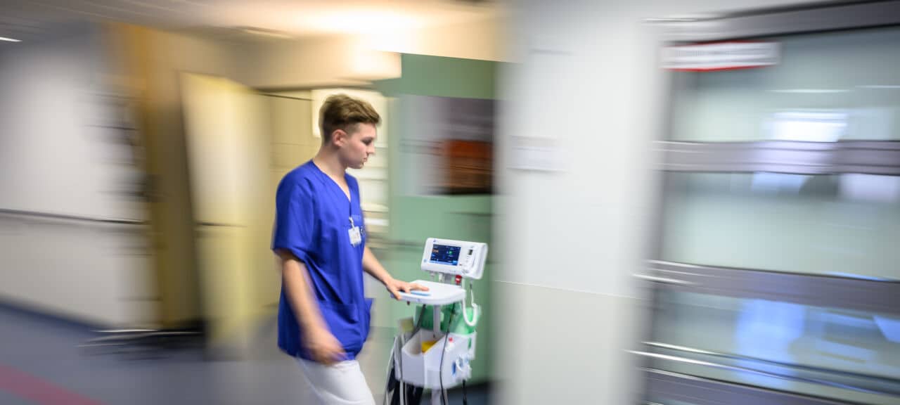 Ein Krankenhaus-Mitarbeiter beziehungsweise Pfleger ist im Krankenhaus zu sehen.